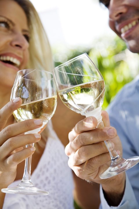 Couple toasting with glasses of white wine